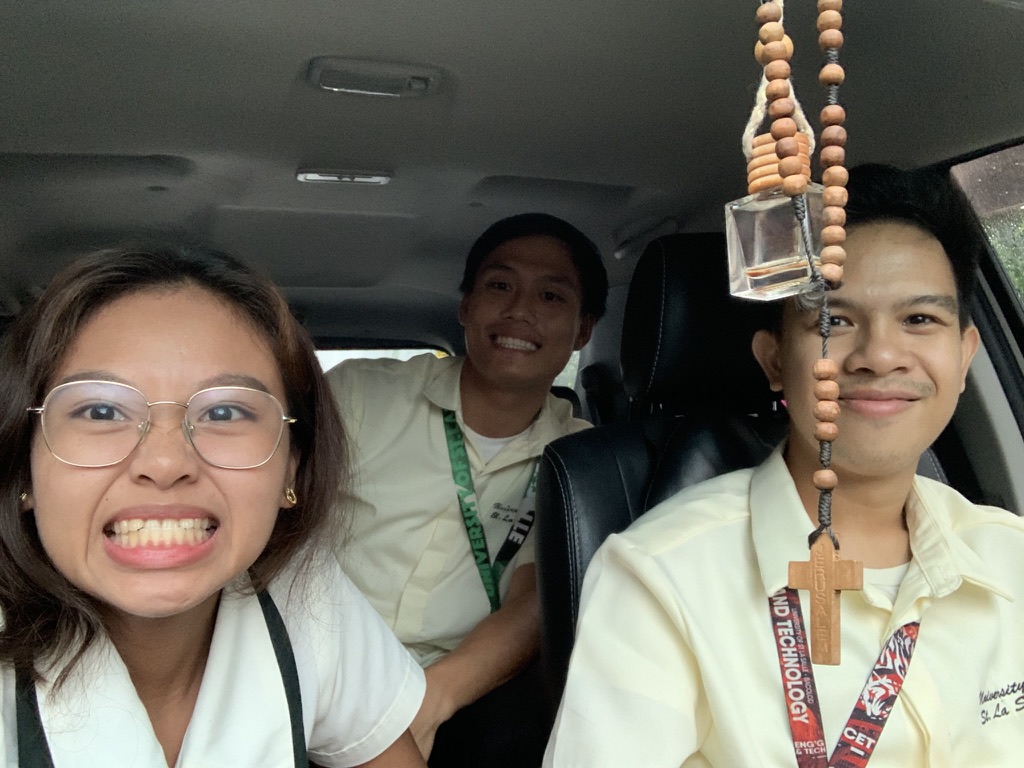 Yolyn and two friends in a car in school uniforms